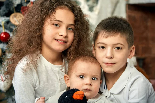 Concetto natalizio e bambini in attesa di un miracolo. Ritratto di diversi bambini sullo sfondo dell'arredamento natalizio, 15 minuti prima della vigilia di Natale. Bambini in attesa di Natale e regali, copia — Foto Stock