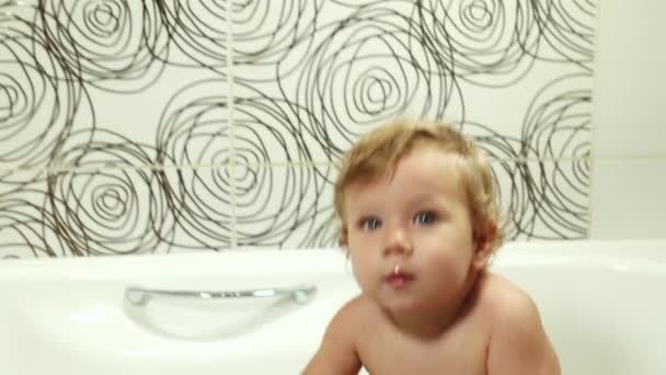 Feliz bebé de ojos azules 9-12 meses se baña en el baño y juega con juguetes, Lavado y bañado de niños, Higiene y cuidado de niños pequeños — Vídeo de stock