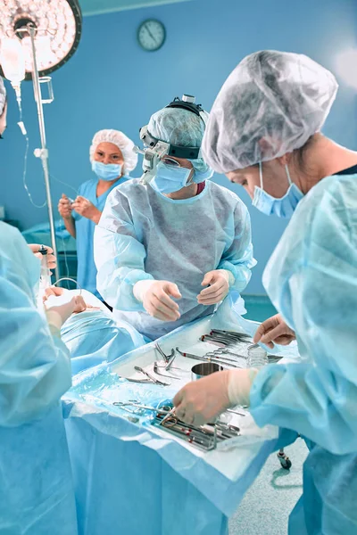 Teknolojik olarak gelişmiş bir hastanede modern bir ameliyat. Yoğun bakımın parlak odası. Ameliyathanede çalışan doktorlar ve asistanlar hayat kurtarıyor.. — Stok fotoğraf