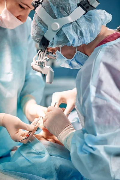 Un médico con guantes sostiene un instrumento médico durante la rinoplastia, reconstrucción de la nariz después de un accidente. Industria de belleza y cirugía plástica . —  Fotos de Stock