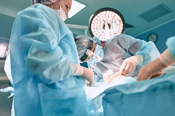 Cirujano usando guantes opera la nariz de las mujeres. Operación de cerca . — Foto de Stock