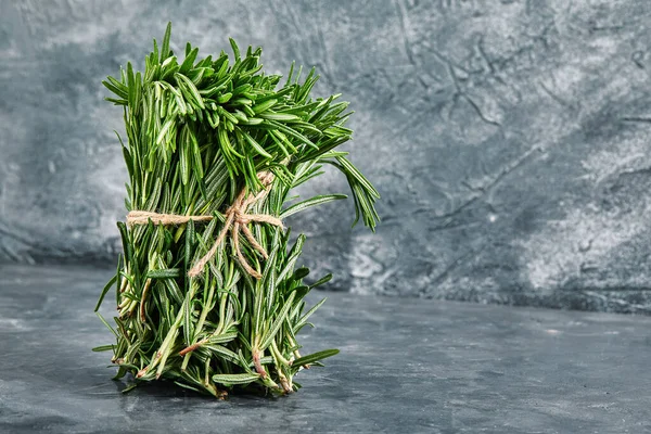 Egy rakás friss rozmaring fonallal összekötve, szürke háttérrel, másolás. Koncepció fotó reklám, termék áruház. — Stock Fotó