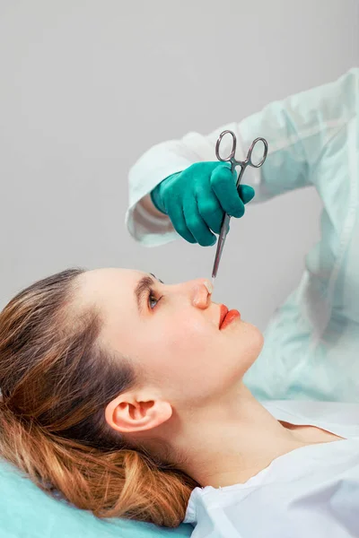 Neuscorrectie, de chirurgische handen raken de neus van de patiënt. Mensen, cosmetologie, plastische chirurgie en schoonheid concept - chirurg of cosmetoloog handen raken vrouwelijk gezicht. Kopieerruimte. — Stockfoto