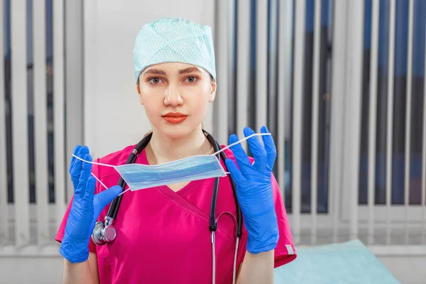 Female doctor takes off mask, victory over virus. The concept of victory over the epidemic, biological, viral. copy space, medicine, saving lives — Stock Photo, Image