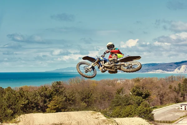 Conceito extremo, desafie-se. Salto extremo em uma motocicleta em um fundo de céu azul com nuvens. Espaço de cópia, tudo ou nada . — Fotografia de Stock