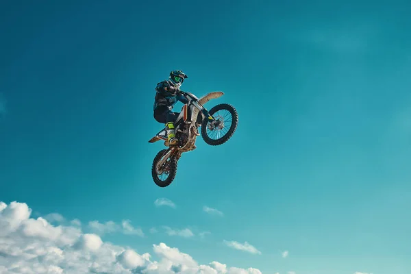 Concepto extremo, desafíate. Salto extremo en una motocicleta sobre un fondo de cielo azul con nubes. Copiar espacio, todo o nada . —  Fotos de Stock