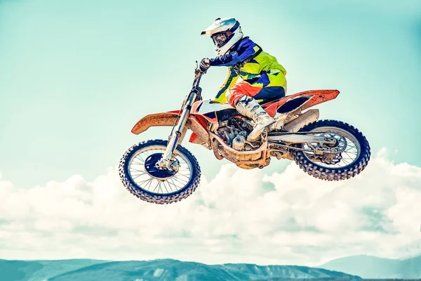Extremt koncept, utmana dig själv. Extremt hoppa på en motorcykel på en bakgrund av blå himmel med moln. Kopiera utrymme, allt eller inget. — Stockfoto