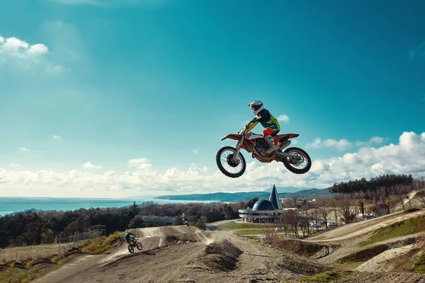 Extreme concept, challenge yourself. Extreme jump on a motorcycle on a background of blue sky with clouds. Copy space, all or nothing. — Stock Photo, Image