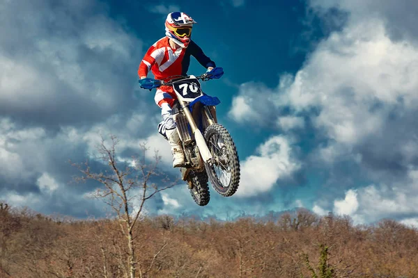 Conceito extremo, desafie-se. Salto extremo em uma motocicleta em um fundo de céu azul com nuvens. Espaço de cópia, tudo ou nada . — Fotografia de Stock