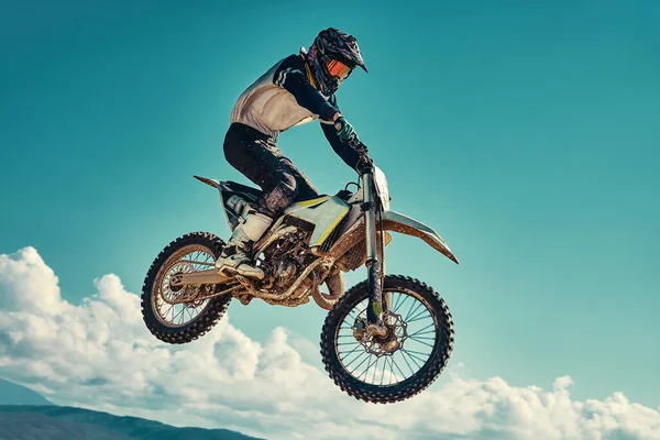 Δρομέας στο ποδήλατο βουνού συμμετέχει σε αγώνα motocross, απογειώνεται και πηδά στο springboard, κατά το μπλε του ουρανού. Κοντινό πλάνο. έννοια της ακραίας ανάπαυσης, σπορ αγωνιστικά. — Φωτογραφία Αρχείου