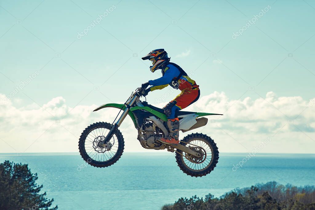 Extreme concept, challenge yourself. Extreme jump on a motorcycle on a background of blue sky with clouds. Copy space, all or nothing.