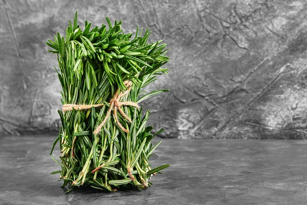 Organic bouquet of fresh rosemary on a gray background. A beautifully tied bunch of fresh grass. Delivery of products, copies of the space. — Stock Photo, Image