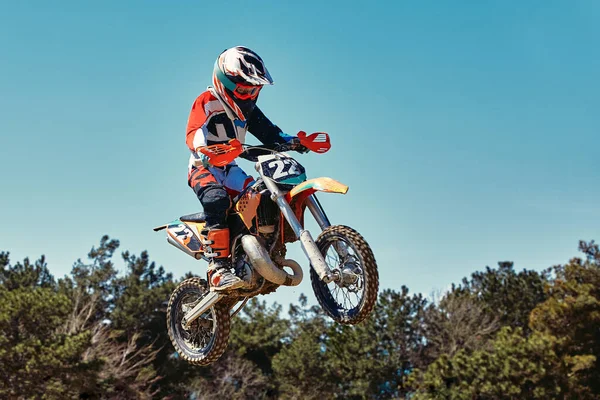 Extreme concept, challenge yourself. Extreme jump on a motorcycle on a background of blue sky with clouds. Copy space, all or nothing.