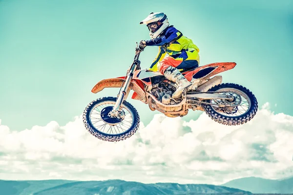 Conceito extremo, desafie-se. Salto extremo em uma motocicleta em um fundo de céu azul com nuvens. Espaço de cópia, tudo ou nada . — Fotografia de Stock