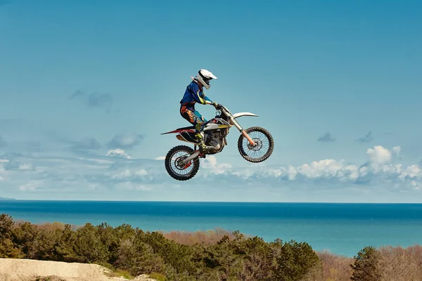 Concepto extremo, desafíate. Salto extremo en una motocicleta sobre un fondo de cielo azul con nubes. Copiar espacio, todo o nada . — Foto de Stock