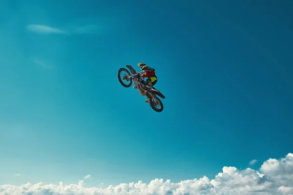 Concepto extremo, desafíate. Salto extremo en una motocicleta sobre un fondo de cielo azul con nubes. Copiar espacio, todo o nada . —  Fotos de Stock