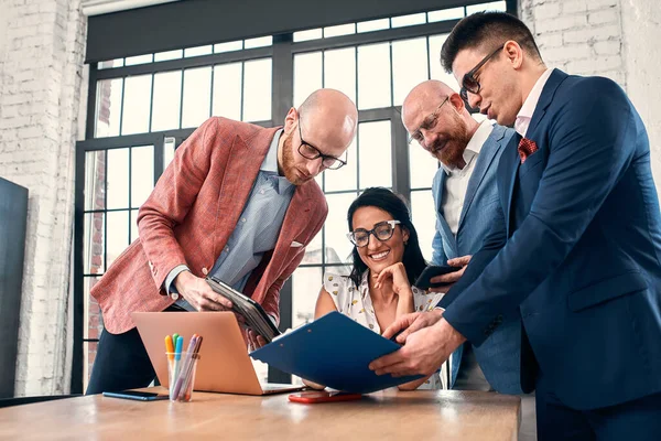 Too many work. Selective focus of young business woman surrounded by colleagues, each proposes a project, asks for approval or signing. Deadline