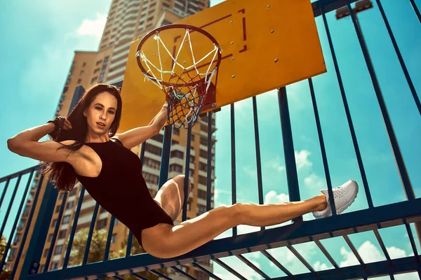 Mujer deportiva fuerte y sexy entrenando al aire libre, en el suelo. saltó a la canasta de baloncesto — Foto de Stock