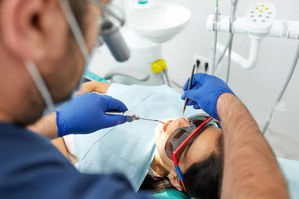 Mensen, geneeskunde, stomatologie en gezondheidszorg concept - gelukkige mannelijke tandarts met vrouw patiënt op tandheelkundige kliniek kantoor — Stockfoto