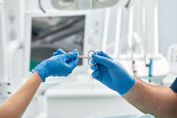 Detailní záběr rukou zubaře a ošetřujícího lékaře na operačním sále během operace zubního implantátu — Stock fotografie