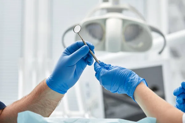 Close-up das mãos de um dentista e enfermeiro cirurgião sobre uma sala de cirurgia durante uma operação de implante dentário — Fotografia de Stock