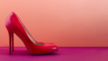 Zarif klasik ayakkabılar, yakın plan. Parlak pembe topuklu ayakkabılar. Pembe ve mor arkaplan.