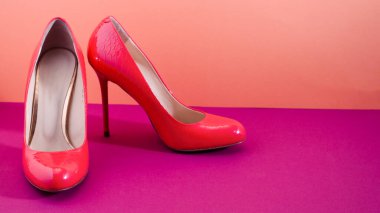 Zarif klasik ayakkabılar, yakın plan. Parlak pembe topuklu ayakkabılar. Pembe ve mor arkaplan.