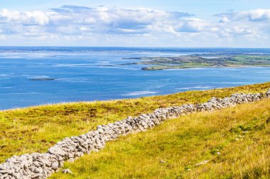 Galway bay içinde geçmiş, Ballyvaughan, Clare, İrlanda ile Burren yol iz içinde taş duvar