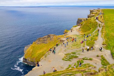Moher Cliffs, Doolin, Clare, İrlanda üzerinde yürüyen insanlar