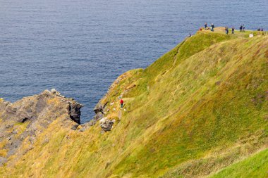 İnsanlar üzerinde kayalıklarla Moher, Doolin, Clare, İrlanda