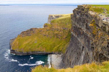 Moher Cliffs, Doolin, Clare, İrlanda üzerinde yürüyen insanlar