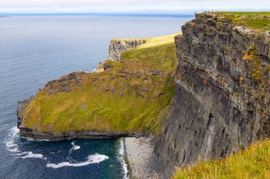 Moher Cliffs, Doolin, Clare, İrlanda üzerinde yürüyen insanlar