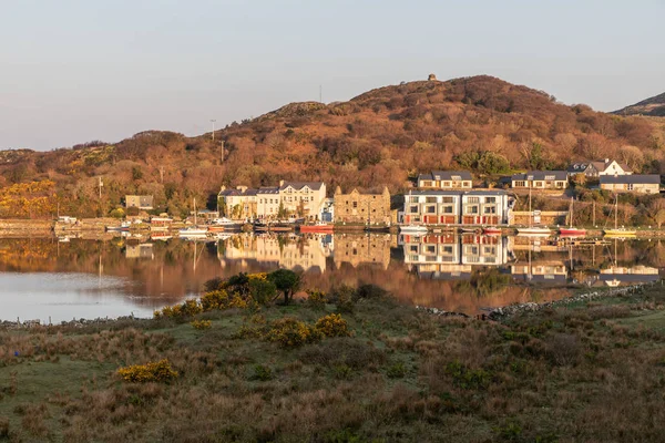 Pier en gebouwen weerspiegeld in Clifden Bay — Stockfoto