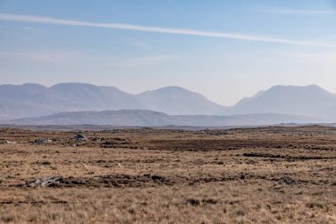 Arka planda On iki Bens dağları ile bir bataklık Kayalar