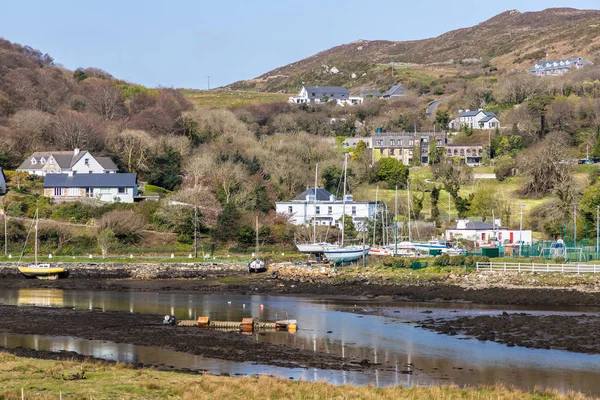 Pier met gebouwen en boot in een laag tij Clifden Bay — Stockfoto