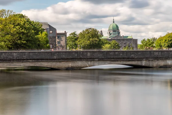 Edificios y puente sobre el río Corrib con Catedral en backgr —  Fotos de Stock