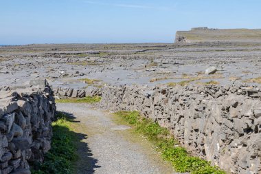 I arka planda kayalıklar ile taş duvar ve kayalar etrafında Yol