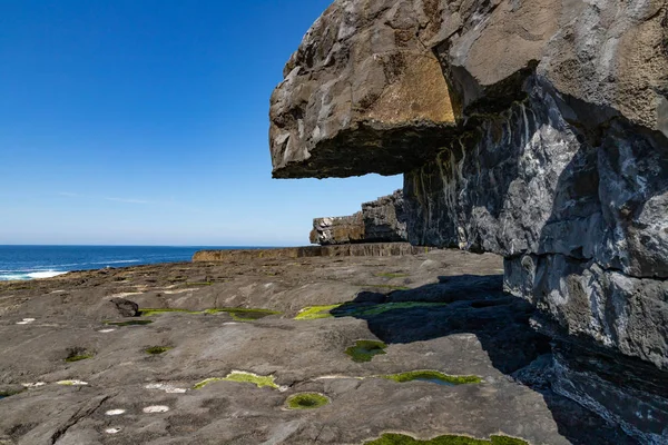 Cliffs  with green sea moss and ocean in Inishmore