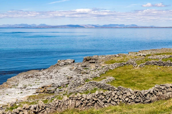 Boerderij veld met rotswanden en Galway Bay op de achtergrond in Inish — Stockfoto