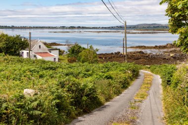 Carraroe arka planda koy ile küçük yol ve ev