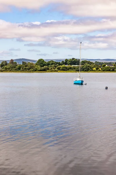 Boat in Lough Corrib with forest and farm fields in background — Stock Photo, Image