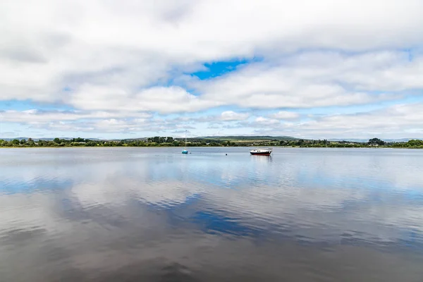 Barca in Lough Corrib con boschi e campi agricoli sullo sfondo — Foto Stock