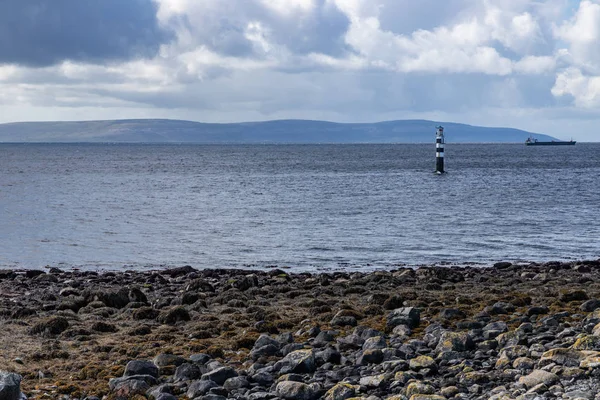 Faro nella baia di Galway con nuvole piovose e montagne brulle i — Foto Stock