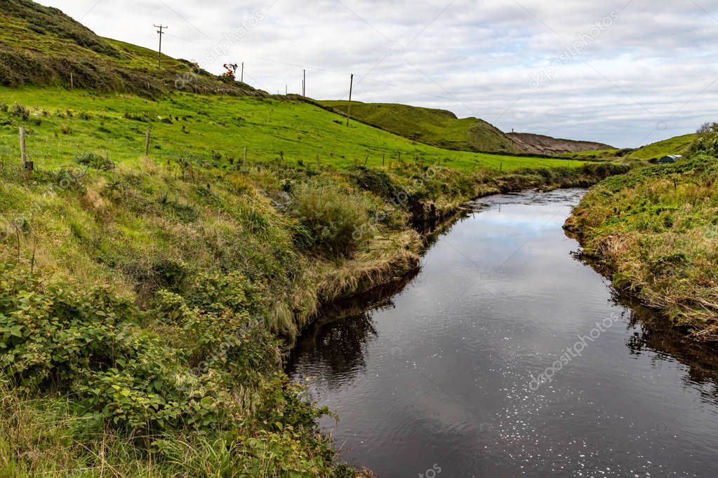 Aille river with vegetation and clouds reflection