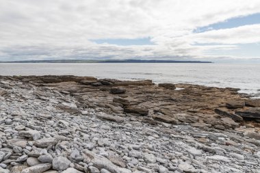 Inisheer 'in arka planında Moher Kayalıkları olan kayalar ve plajlar.