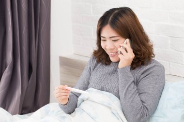 Telefon kullanarak ve kocası ile hamile haber arama Asyalı kadın 