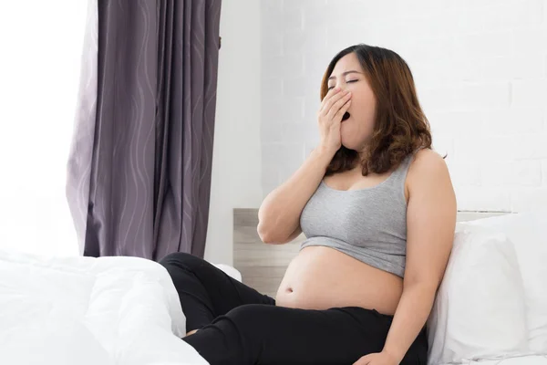 Сонная Азиатская Беременная Женщина Зевает Постели Дома — стоковое фото