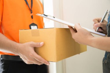 Kadın kurye, teslimat kavramı parsel aldıktan sonra tablet imza ekleme