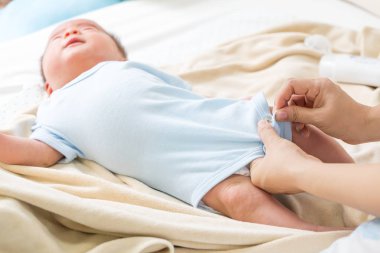 Anne Bebek için bir elbise giyiyor