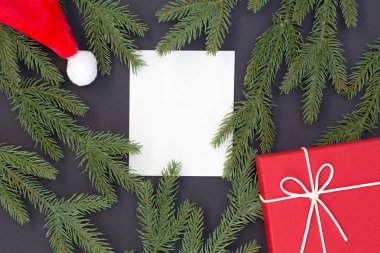 Siyah arka plan ve kopya alanı beyaz kağıt, metniniz için Noel ve mutlu yeni yıl kompozisyon, hediye kutusu, çam kozalakları, çam dalları üstten görünüm
